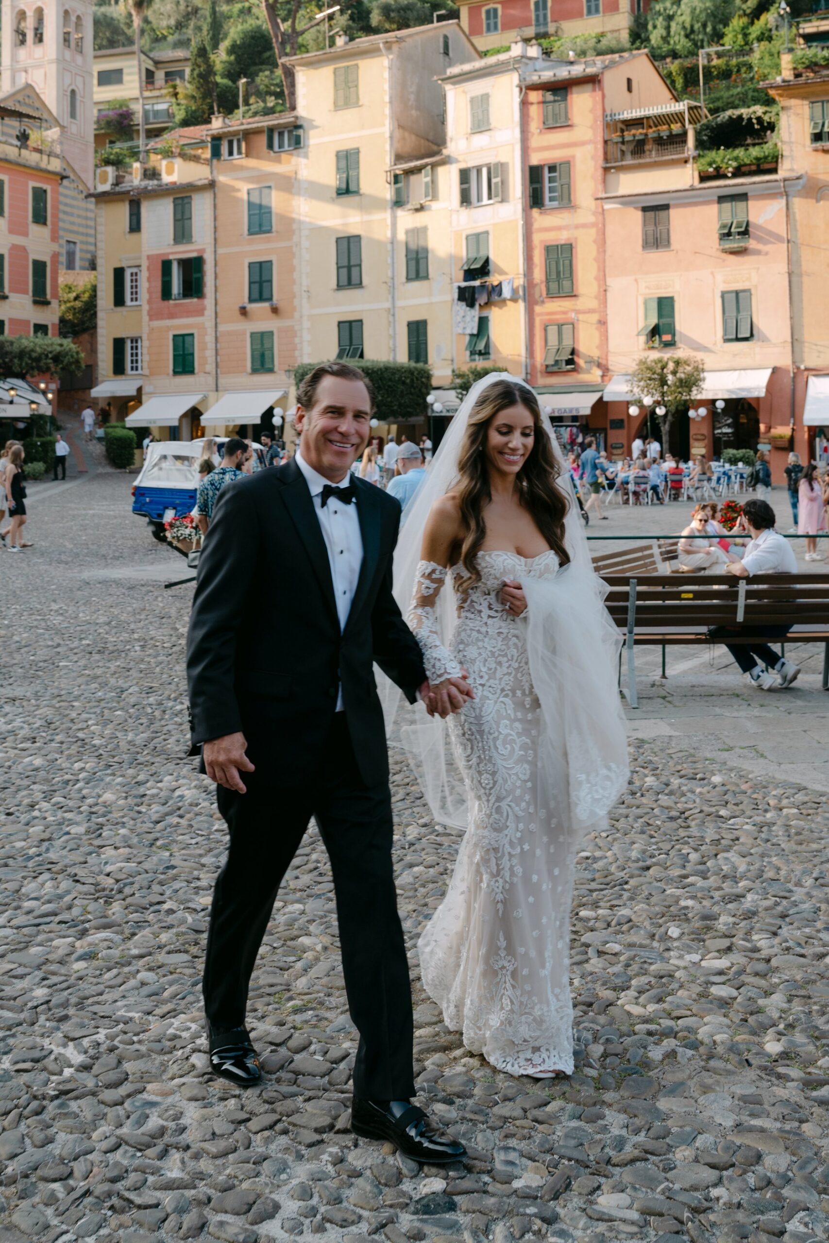 Couple walking in Portofino piazzetta with colourful houses — portofino elopement at Belmond Hotel Splendido