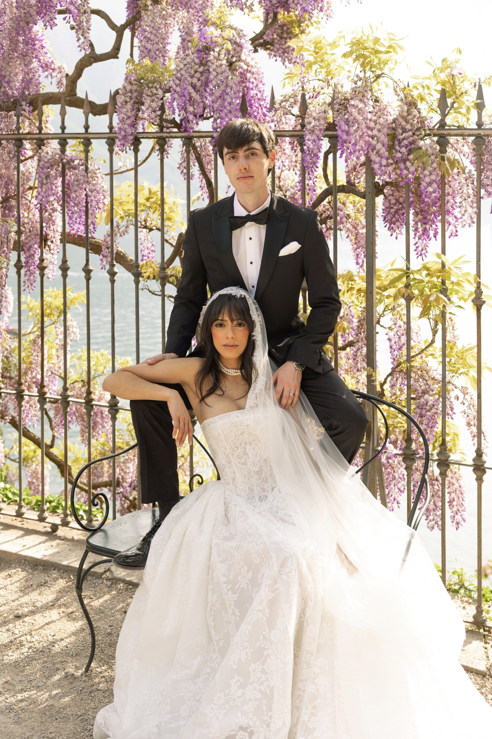 Couple portrait among flowering wisteria at Villa del Balbianello — april lake como micro wedding
